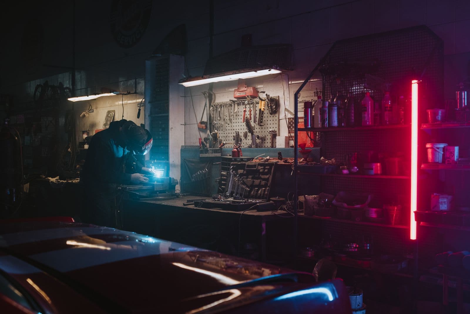 Mechanic welding in a garage at night
